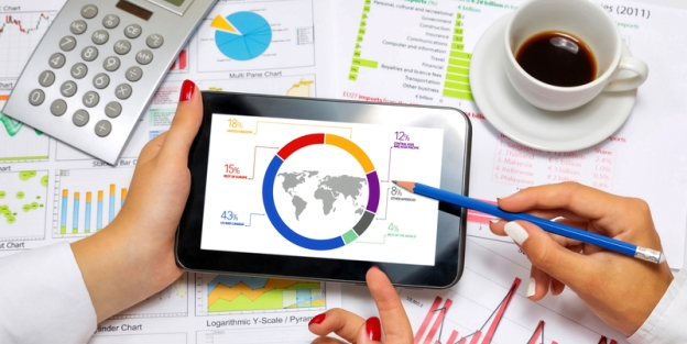 Hands around tablet assessing map with numbers and other information on table