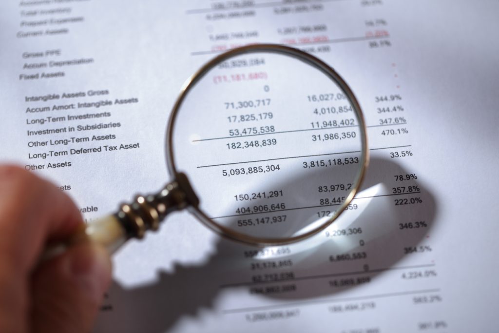 Magnifying glass examining financial statements