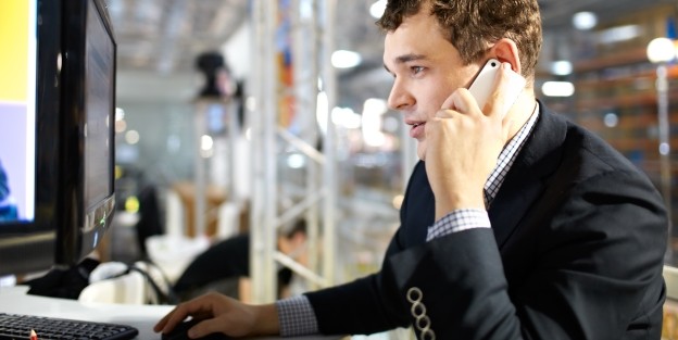 Man on phone staring at computer in office