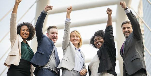 Happy business team pumping fists in the air