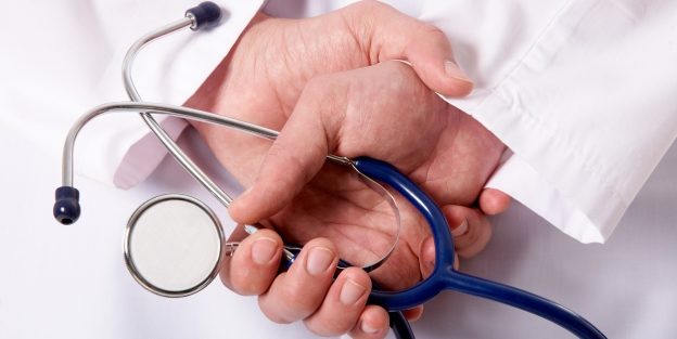Hands of practitioner with stethoscope