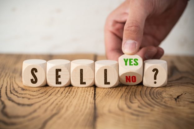 cubes with the word "SELL" and hand turning a cube with answer "yes" and "no"