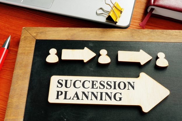 Chalk board with succession planning on it and arrows connecting different people
