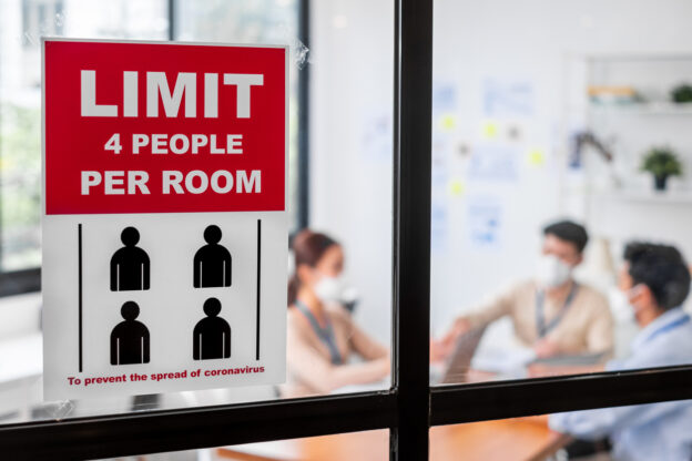 View of meeting room with employees wearing masks