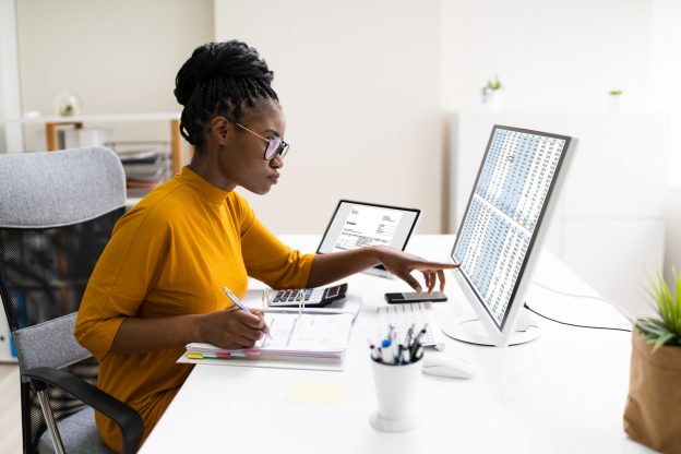 Woman checking financial figures on computer screen