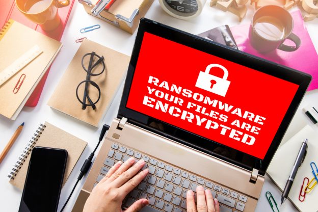 Laptop computer with red screen showing ransomeware attackl