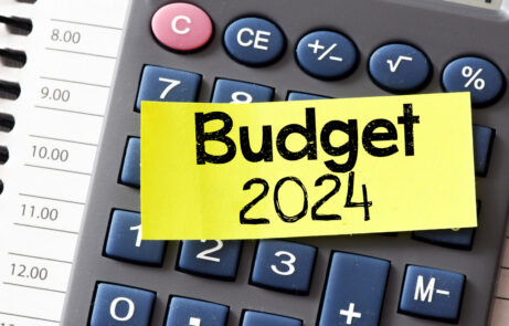 BUDGET 2024 text on a small yellow piece of paper lying on top of the calculator.