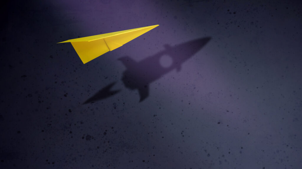 Start-up Company and Motivation in Business Concept. Paper Planes Flying with Shadow of Rocket over the Wall