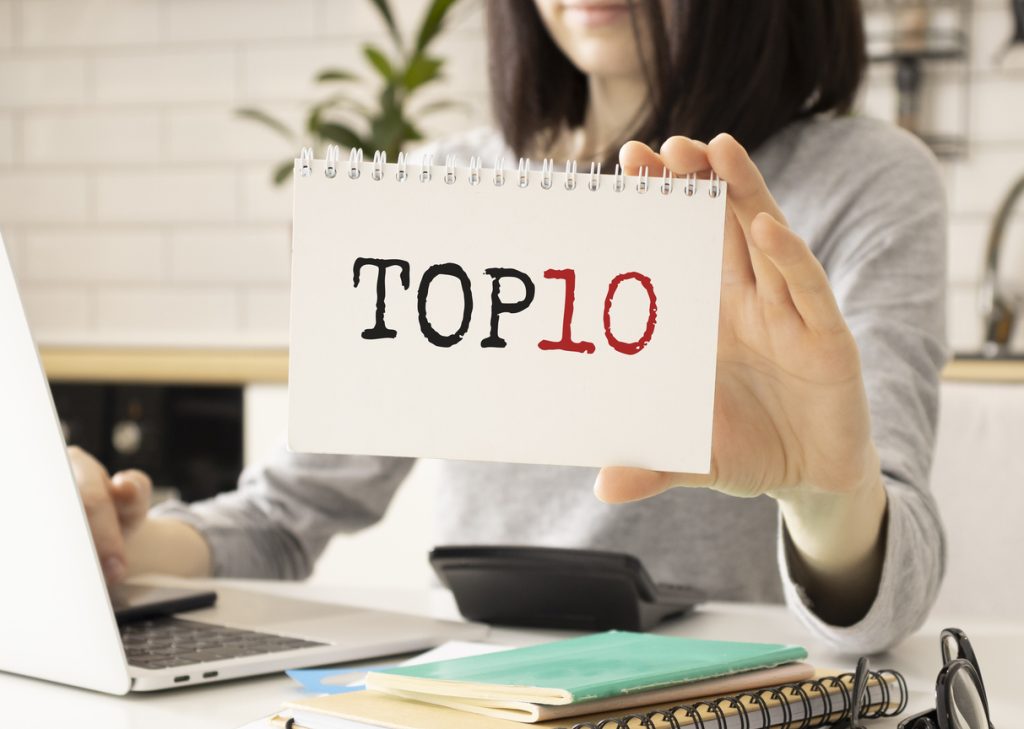 Top 10 text on notebook in hand businesswoomen.