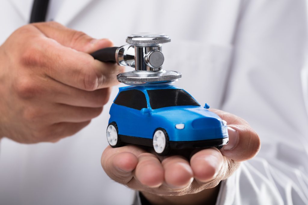 Doctor examining blue car